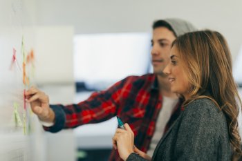 junge Auszubildende arbeiten am Whiteboard