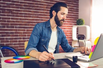 Mann sitzt an seinem Arbeitsplatz vor seinem Laptop