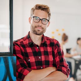junger Mann mit Brille und verschränkten Armen