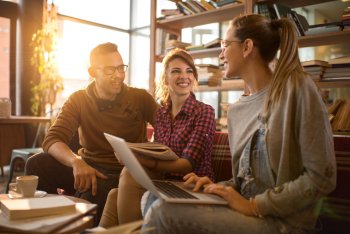 zwei junge Frauen und ein Mann unterhalten sich