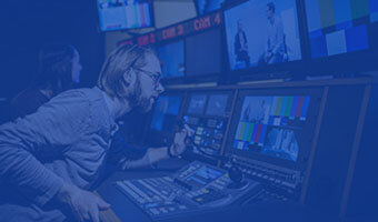 Filmwissenschaft Master Student sitzt vor Bildschirmen im Recording Raum