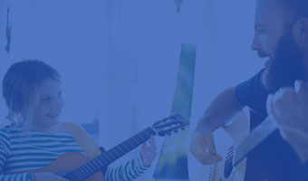 Musiktherapeut hat eine Sitzung mit einem kleinen Mädchen, beide spielen Gitarre